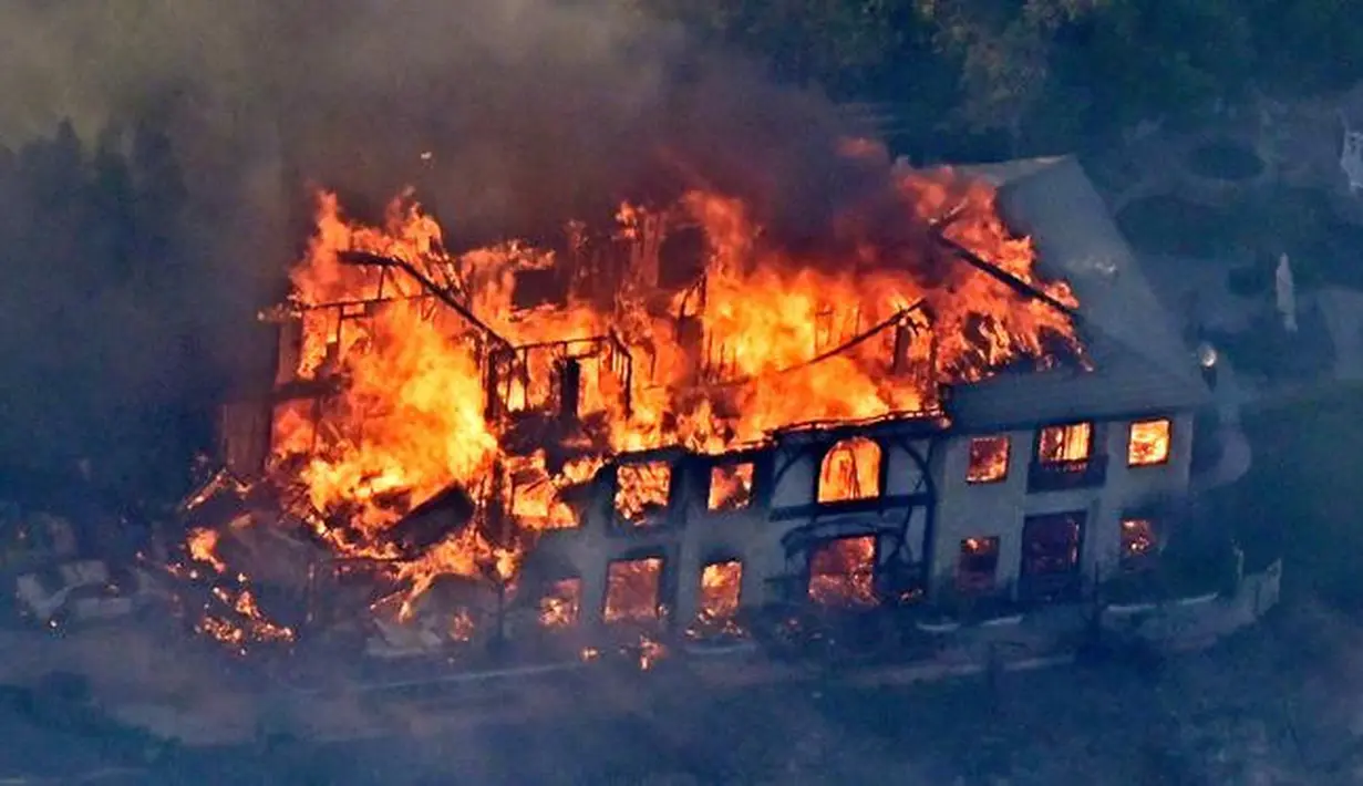 Sebuah rumah terbakar saat kebakaran melanda Calabasas, Los Angeles, California, AS, Jumat (9/11). Pemerintah setempat mendeklarasikan udara tak sehat serta memerintahkan warga untuk tak bepergian. (AP Photo/Mark J. Terrill)