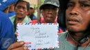 Seorang tukang becak menunjukkan amplop berisi surat untuk Gubernur DKI, Basuki Tjahaja Purnama saat melakukan unjuk rasa di Balai Kota Jakarta, Kamis (28/1). Aksi tersebut terkait larangan para tukang becak untuk beroperasi. (Liputan6.com/Yoppy Renato)