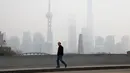 Warga berjalan ditengah kabut asap tebal yang menyelimuti Shanghai, Cina, 2 Januari 2017. Kabut tebal ini membuat sejumlah warga mengunakan masker saat beraktivitas. (REUTERS/Aly Song)