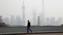 Warga berjalan ditengah kabut asap tebal yang menyelimuti Shanghai, Cina, 2 Januari 2017. Kabut tebal ini membuat sejumlah warga mengunakan masker saat beraktivitas. (REUTERS/Aly Song)