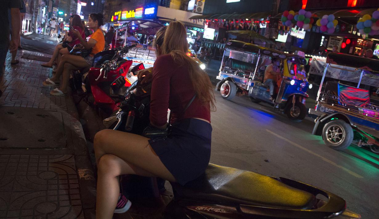 Foto pada 11 Oktober 2018 menunjukkan sejumlah wanita berkumpul di trotoar Nana Red Light Distrik, Bangkok, Thailand. Nana Red Light District memang dikenal sebagai kawasan hiburan malam terbesar di Bangkok. (Romeo GACAD / AFP)
