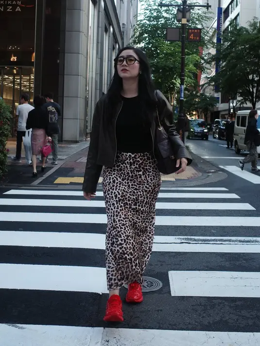 Look satu ini menjadi salah satu outfit paling standout. Febby memadukan rok leopard panjang dengan atasan hitam fitted dan cropped leather jacket. Yang paling mencuri perhatian tentu sneakers merah terang yang memberi aksen bold pada keseluruhan outfit monokrom.[@febbyrastanty].
