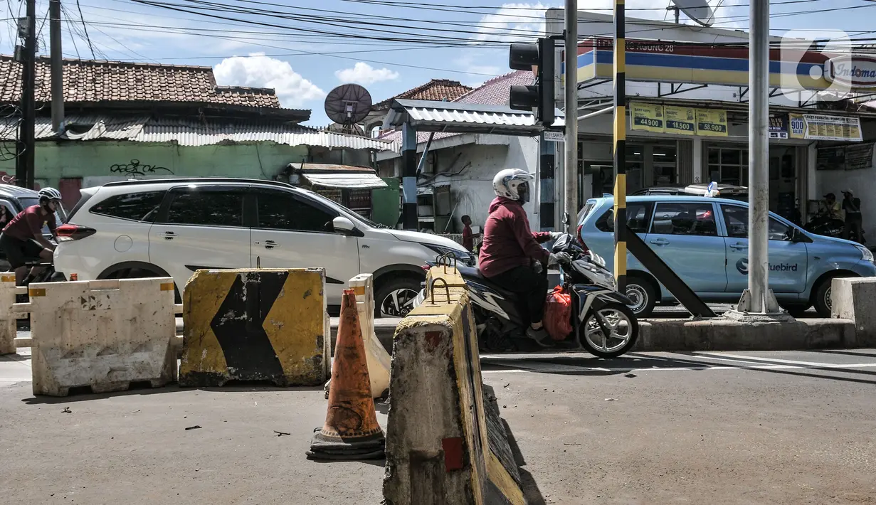 Pengendara motor menerobos separator yang menutup akses jalan layang atau flyover tapal kuda Lenteng Agung, Jakarta, Minggu (28/2/2021). Minimnya pengawasan menyebabkan banyak pengendara sepeda motor nekat menerobos flyover tapal kuda Lenteng Agung yang masih ditutup. (merdeka.com/Iqbal S Nugroho)