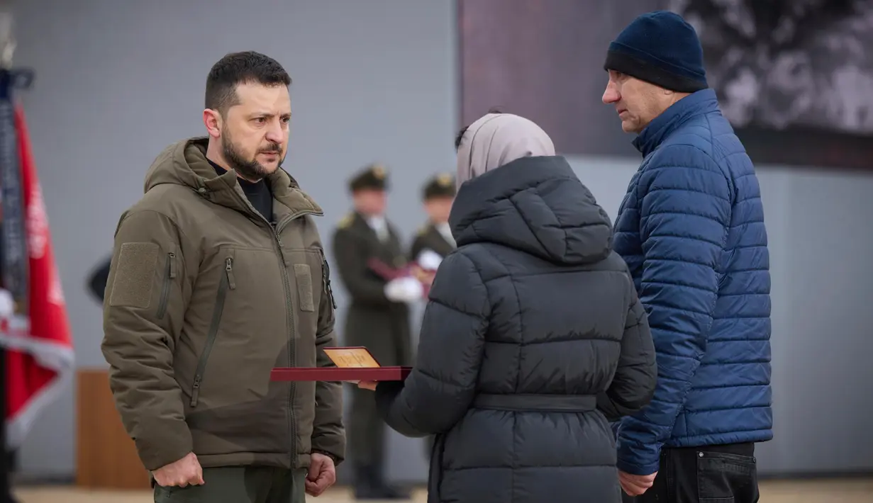 Presiden Ukraina Volodymyr Zelenskyy (kiri) memberikan penghargaan Pahlawan Ukraina kepada kerabat seorang tentara yang terbunuh dalam sebuah acara peringatan satu tahun perang Rusia-Ukraina di Kyiv, Ukraina, Jumat, 24 Februari 2023. (Kantor Pers Kepresidenan Ukraina via AP)