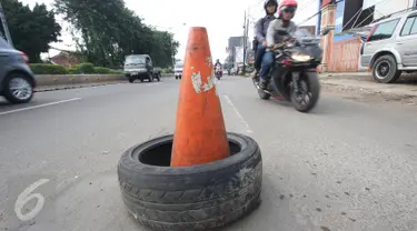 Kendaraan menghindari penanda lubang di Jalan Otista Raya, Jakarta, Rabu (22/2). Kondisi tersebut berbahaya bagi pengguna jalan, khususnya pengendara sepeda motor yang melintas saat malam hari. (Liputan6.com/Immanuel Antonius)