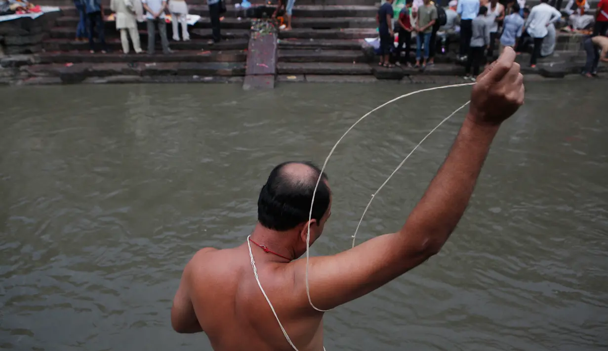 Seorang umat Hindu Nepal melakukan ritual selama festival Janai Purnima di kuil Pashupati di Kathmandu, Nepal (28/7). (AP Photo / Niranjan Shrestha)