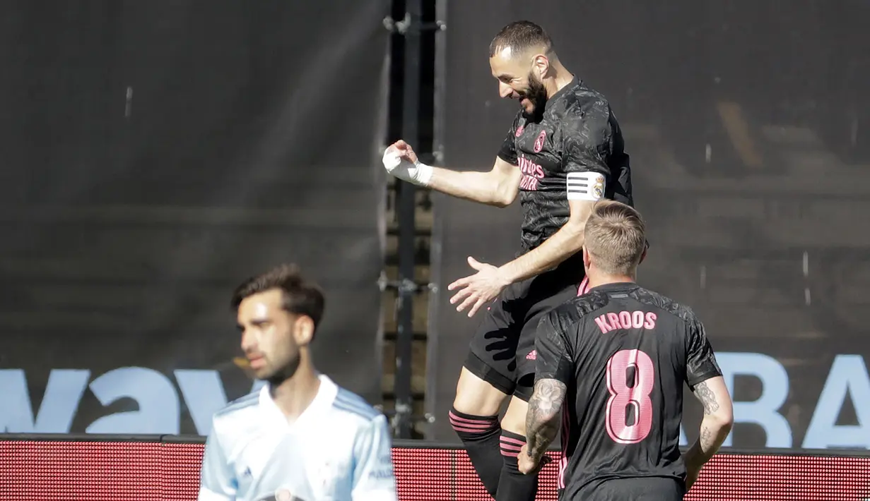 Striker Real Madrid, Karim Benzema (atas) melakukan selebrasi usai mencetak gol pertama timnya ke gawang Celta Vigo dalam laga lanjutan Liga Spanyol 2020/2021 pekan ke-28 di Balaidos Stadium, Sabtu (20/3/2021). Real Madrid menang 3-1 atas Celta Vigo. (AP/Lalo R. Villar)