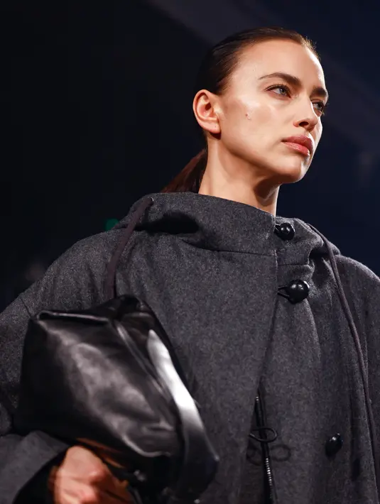<p>Model Rusia Irina Shayk mempersembahkan kreasi dari koleksi Isabel Marant Womenswear Fall-Winter 2023-2024 pada Paris Fashion Week di Paris, Prancis, 2 Maret 2023. Mantel wol yang dikancingkan pada bagian leher, dipasangkan dengan gaun mini berwarna abu-abu tua serasi dan selipan tas tangan kulit di bawah lengannya. (Vianney Le Caer/Invision/AP)</p>