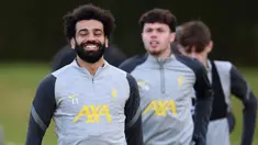 Pemain Liverpool Mohamed Salah (kiri) tertawa saat sesi latihan bersama rekan setimnya di tempat latihan mereka di Kirkby, Inggris, 6 Desember 2021. Liverpool akan menghadapi AC Milan pada pertandingan Grup B Liga Champions. (Oli SCARFF/AFP)
