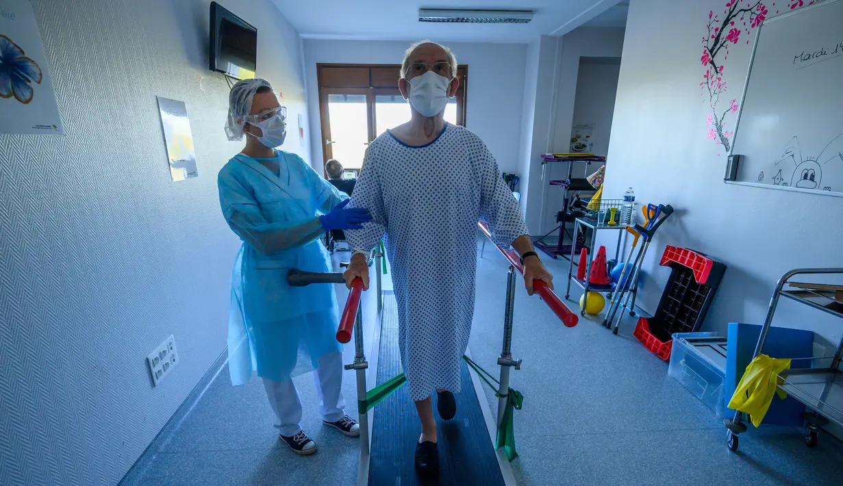 Fisioterapis merawat pasien yang sedang menjalani proses rehabilitasi setelah sembuh dari infeksi virus corona COVID-19 di sebuah rumah sakit di Illkirch-Graffenstaden, Prancis, Selasa (14/4/2020). Prancis memperpanjang lockdown karena dinilai ampuh menahan kasus baru COVID-19. (PATRICK HERTZOG/AFP)
