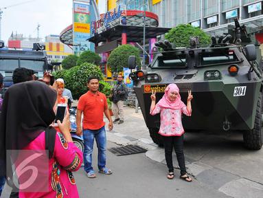 Seorang perempuan berselfie di depan panser Anoa milik TNI di LTC Glodok, Jakarta, Jumat (4/11). Anoa itu diparkir di depan LTC Glodok untuk mengantisipasi jika terjadi kerusuhan di pusat perbelanjaan tersebut. (Liputan6.com/Angga Yuniar)