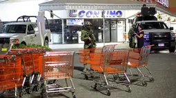 Polisi marinir berjaga di super market usai penjarahan di pelabuhan Veracruz, Meksiko, (4/1). Kepolisian menyebut sebanyak 300 toko digeledah dan lebih dari 600 orang ditangkap. (AP Photo/Felix Marquez)