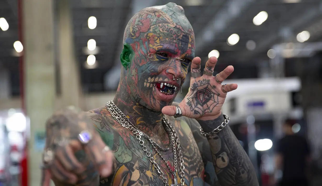 Seniman tato asal Brasil Marcelo B. Boy berpose memamerkan tato, tindikan, dan lidahnya yang dimodifikasi dalam acara Sao Paulo Tattoo Week, Brasil, Jumat (25/10/2019). (AP Photo/Andre Penner)