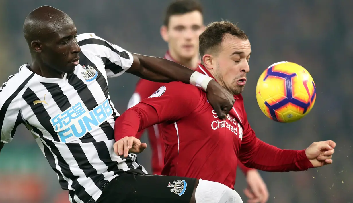 Pemain Newcastle United, Mohamed Diame berebut bola dengan pemain Liverpool Xherdan Shaqiri pada pertandingan Liga Inggris di Stadion Anfield, Rabu (26/12). Liverpool berpesta gol ke gawang Newcastle United, 4-0. (AP/Jon Super)