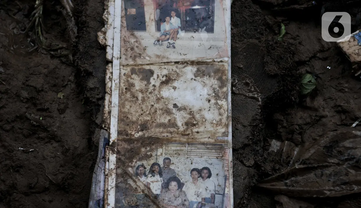 Buku foto tergeletak di depan rumah satu warga pascabanjir di kawasan Rawajati, Pancoran, Jakarta, Minggu (5/1/2020). Puluhan rumah warga yang berada di bantaran Kali Ciliwung itu mengalami kerusakan parah dan dipenuhi sampah serta lumpur akibat terjangan banjir. (merdeka.com/Iqbal Nugroho)
