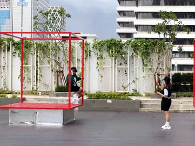 Pengunjung berpose saat menanti waktu berbuka puasa di Sky Deck Sarinah, Jakarta, Kamis (7/4/2022). Sky Deck Sarinah menjadi salah satu destinasi baru bagi warga Jakarta dan sekitarnya untuk menanti waktu berbuka puasa atau ngabuburit bersama keluarga dan kerabat. (Liputan6.com/Herman Zakharia)