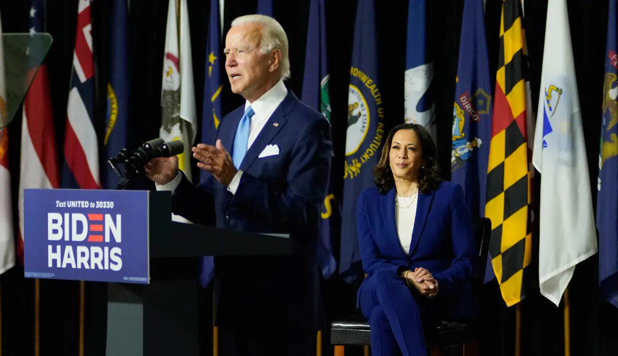 Calon Wakil Presiden Partai Demokrat, Kamala Harris mendengarkan Joe Biden selama acara kampanye di Alexis Dupont High School di Wilmington, Delaware, Rabu (12/8/2020).  Acara itu menjadi penampilan perdana keduanya di depan publik sebagai pasangan capres-cawapres. (AP Photo/Carolyn Kaster)