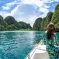 Foto diambil pada 4 Oktober 2019, seorang turis berpose di atas perahu di depan garis batas yang ditetapkan oleh Departemen Taman Nasional, Margasatwa dan Konservasi Tumbuhan Thailand untuk menutup pantai di Maya Bay bagi pengunjung di pulau selatan Thailand, Koh Phi Phi. (MLADEN ANTONOV / AFP)