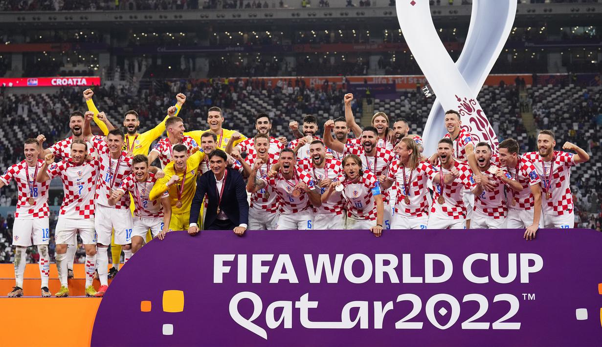 Sejumlah pemain dan pelatih Kroasia merayakan kegembiraan setelah pengalungan medali peringkat ketiga Piala Dunia 2022 di Khalifa International Stadium, Minggu (18/12/2022). (AP Photo/Hassan Ammar)