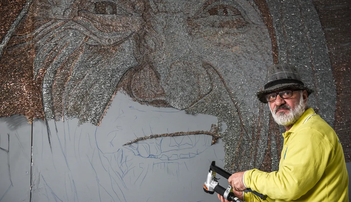 Seniman asal Albania, Saimir Strati saat membuat karya mosaik wajah Suster Teresa menggunakan 1,5 juta keping staples di Museum Pristina, Kosovo (16/11). (AFP/Armend Nimani)