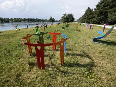 Pemandangan instalasi 'Rainbow Park', oleh desainer dan seniman Stefano Rossetti, di danau buatan Idroscalo, di Milan, Italia, Selasa (22/6/2021). Instalasi yang terdiri dari furnitur jalanan, patung, dan benda logam berwarna, akan dipajang hingga Juni 2022. (AP Photo/Luca Bruno)