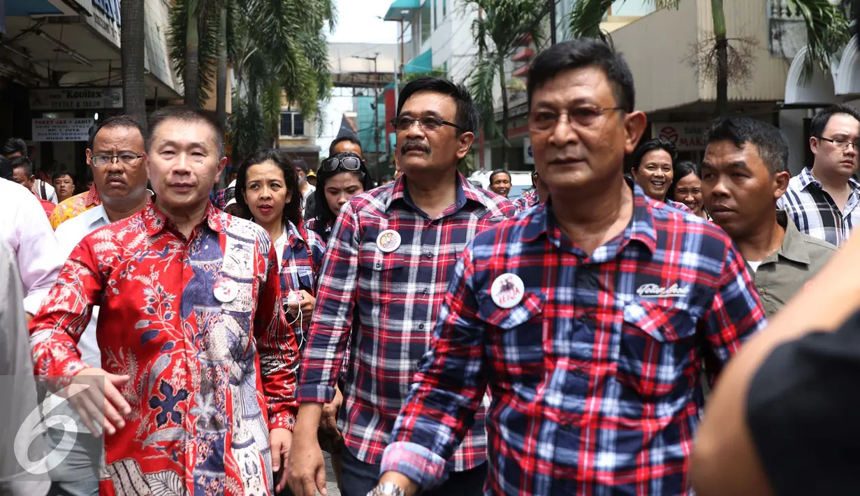 Djarot Saiful Hidayat berjalan bersama rombongannya saat blusukan di kawasan Pasar Baru, Jakarta, Senin (14/11). Sebelumnya Djarot sempat mendapat penolakan dari sejumlah warga saat blusukan ke kawasan ini. (Liputan6.com/Gempur M. Surya)