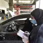 Mekanik wanita Saudi membuat catatan di sebelah kendaraan di bengkel perbaikan dan servis di Jeddah, Arab Saudi (27/12/2021). Wanita Arab Saudi kini mulai mendapat kesempatan bekerja di area yang sebelumnya dianggap hanya identik pria seperti di toko suku cadang mobil di Jeddah. (AFP/Amer Hilabi)