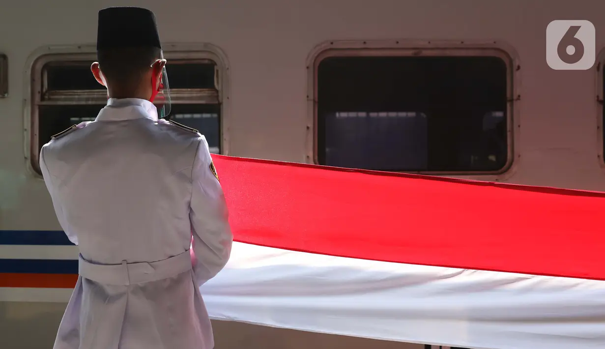 Personel Paskibra membentangkan bendera Merah Putih di Stasiun Pasar Senen, Jakarta, Senin (17/8/2020). Dalam rangka peringatan ke-75 tahun Hari Kemerdekaan Indonesia, PT KAI Daop 1 Jakarta mengadakan upacara pembentangan Bendera Merah Putih sepanjang 17 meter. (Liputan6.com/Helmi Fithriansyah)