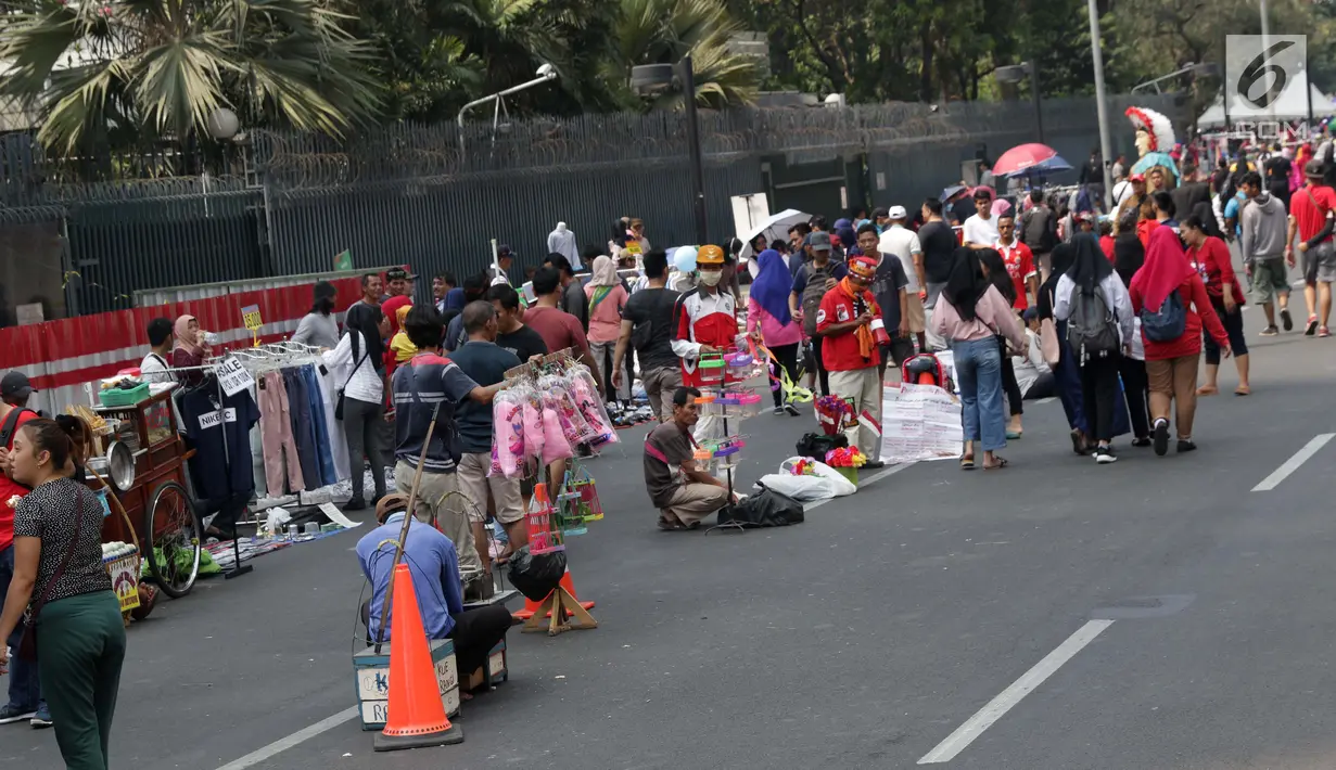 Pedagang kaki lima (PKL) menggelar dagangannya di Jalan Jenderal Sudirman saat Hari Bebas Kendaraan, Jakarta, Minggu (25/8/2019). Para PKL ini menggelar dagangannya terlalu menjorok ke tengah jalan sehingga mengganggu kenyamanan warga yang berolahraga saat CFD. (Liputan6.com/Helmi Fithriansyah)