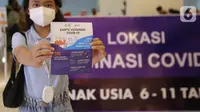 Seorang anak menunjukkan kartu vaksinasi usai menjalani vaksin di Lippo Mall Kemang, Jakarta Selatan, Minggu (16/01/2022). Kegiatan Vaksinasi sebagai bentuk peran aktif dan sinergi PT Lippo Malls Indonesia dalam mendukung percepatan tercapainya vaksinasi nasional. (Liputan6.com/Fery Pradolo)