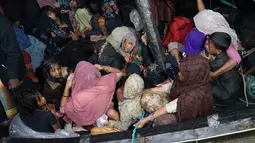 Pengungsi Rohingya duduk di perahu saat tiba di Pelabuhan Krueng Geukueh di Aceh Utara, Jumat pagi (31/12/2021). Pengungsi Rohingya tiba di Pelabuhan Asean, Kreueng Geukeuh, Kabupaten Aceh Utara, pada Kamis (30/12/2021) malam, setelah kapal motornya ditarik KRI Parang-647. (AP Photo/M. Yasir)