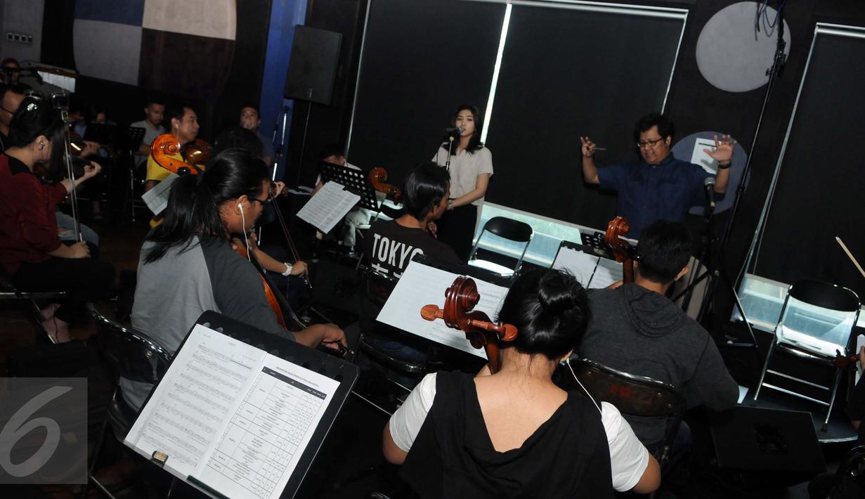 Isyana Sarasvati saat latihan bersama Erwin Gutawa Orchestra di kawasan Cilandak, Jakarta, Minggu (21/8). Pada malam puncak HUT SCTV ke-26 nanti, akan menjadi kali pertama Isyana diiringi oleh orkestra kenamaan Tanah Air. (Liputan6.com/Helmi Afandi)