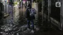 Warga berjalan menerjang banjir karena hujan di Jalan Shofa Marwah, Jakarta, Jumat (4/11/2022). Berdasarkan laporan Badan Penanggulangan Bencana Daerah (BPBD) DKI Jakarta yang diperbaharui pada pukul 18.00 WIB, terdapat 4 RT yang terendam banjir dengan ketinggian maksimal mencapai 50 Cm. (Liputan6.com/Faizal Fanani)