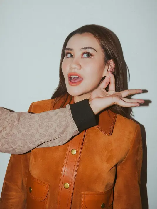 Aaliyah Massaid tampil cantik dengan set atasan berkerah lengan panjang dari kulit berwarna cokelat, dipadu roknya dengan detail kantong, yang serasi. Aaliyah Massaid menyempurnakan penampilannya dengan makeup bernuansa oranye yang lembut dan rambut panjangnya yang dibiarkan tergerai. [Foto: Instagram/erichalamin]