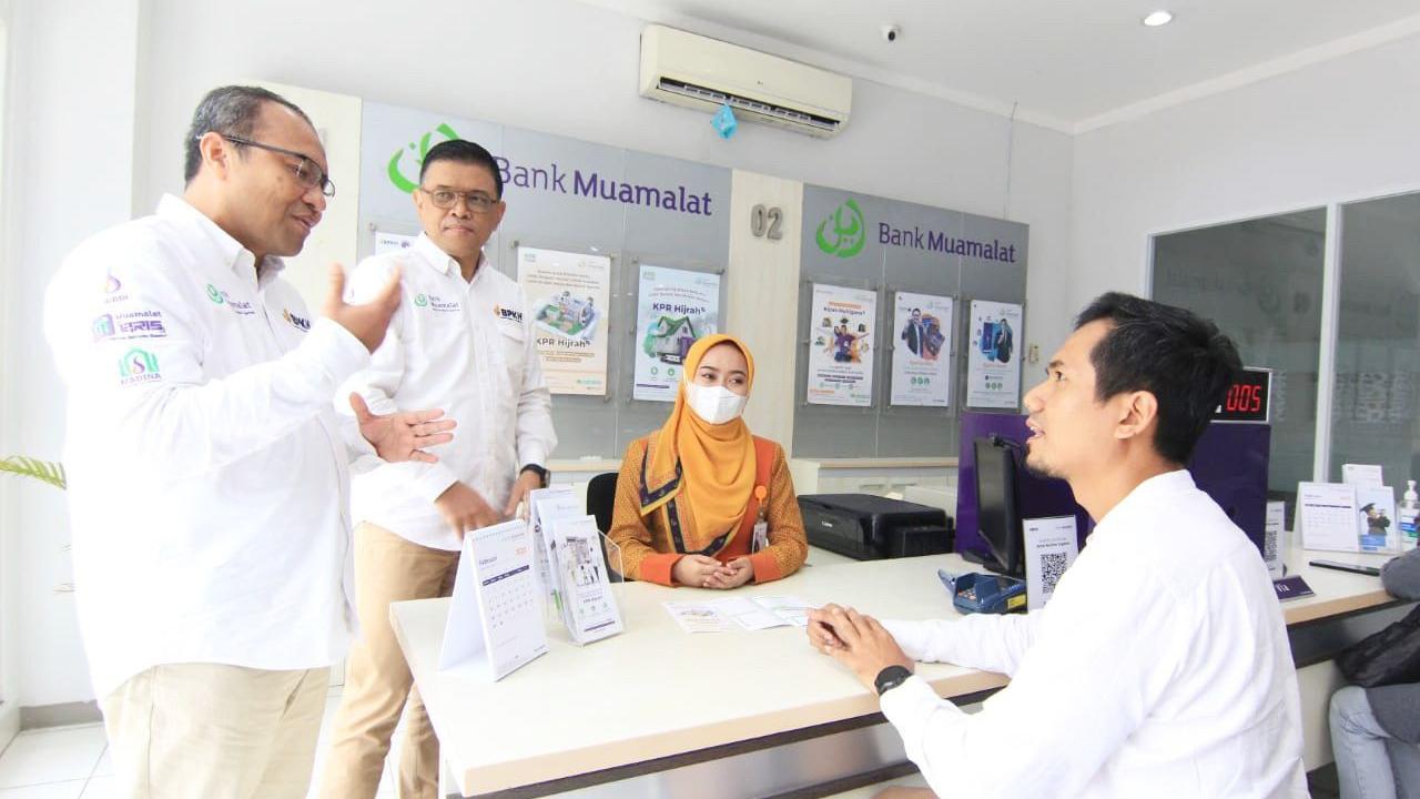 Direktur Bank Muamalat Wahyu Avianto (kiri) dan Head of Distribution & Network Management Bank Muamalat Agung Prambudi (kedua kiri) berbincang dengan nasabah tentang produk KPR Hijrah. (Dok Bank Muamalat)