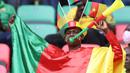 Seorang Suporter Kamerun meniup terompet sambil bersorak menjelang upacara pembukaan turnamen Piala Afrika (CAN) 2021 di Stade d'Olembé di Yaounde (9/1/2022). Kamerun untuk kali kedua menjadi tuan rumah Piala Afrika setelah pada 1972. (AFP/Kenzo Tribouillard)