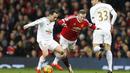  Pemain Manchester United,  Wayne Rooney  mencoba melewati dua pemain Swansea City pada lanjutan Liga Premier Inggris di Stadion Old Trafford, Sabtu (02/01/2016). Manchester United menang 2-1. (Reuters/Carl Recine)