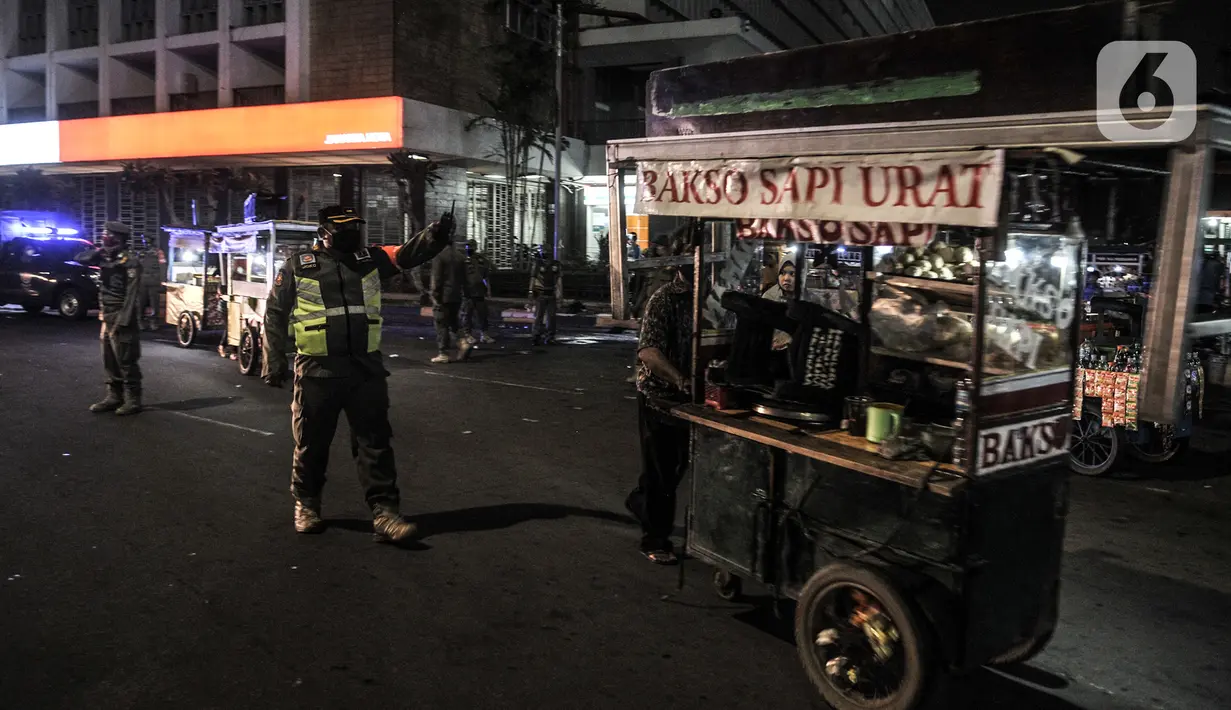 Pedagang membawa dagangannya saat petugas Satpol PP melakukan penertiban di kawasan Kota Tua, Jakarta, Kamis (31/12/2020). Penertiban dilakukan guna mencegah kerumunan seiring larangan bagi warga merayakan malam Tahun Baru di Kota Tua di tengah pandemi COVID-19. (merdeka.com/Iqbal S. Nugroho)