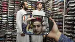 Seorang pria mencoba topi tradisional dalam persiapan untuk bulan puasa Ramadhan yang akan datang, di Peshawar, Pakistan, Sabtu (2/4/2022). Bulan Ramadhan atau sering kita sebut bulan puasa adalah bulan yang di tunggu-tunggu oleh umat Islam di seluruh dunia. (AP Photo/Muhammad Sajjad)
