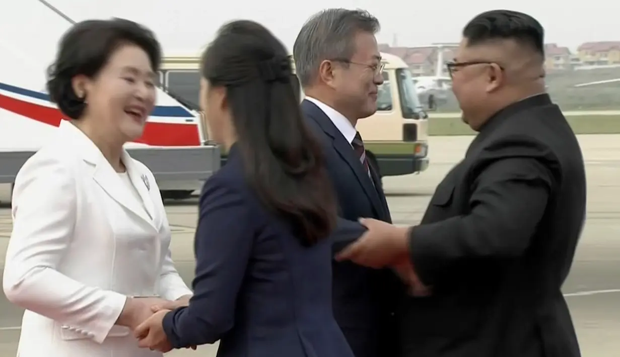 Gambar dari video yang disediakan oleh KBS, Presiden Korea Selatan, Moon Jae-in dan istrinya Kim Jung-sook disambut oleh pemimpin Korea Utara, Kim Jong-un dan sang istri, Ri Sol Ju setibanya di Pyongyang, Selasa (18/8). (Korea Broadcasting System via AP)