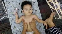 Seorang bayi mengikuti acara pijat massal bayi di Gedung Kementerian Kesehatan, Jakarta, Selasa (7/11). Acara tersebut digelar dalam rangka menyambut peringatan Hari Kesehatan Nasional ke-53. (Liputan6.com/Immanuel Antonius)