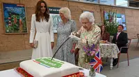 Ratu Inggris Elizabeth II mencoba memotong kue dengan pedang, yang dipinjamkan kepadanya oleh The Lord-Letnant of Cornwall, Edward Bolitho, untuk merayakan inisiatif 'The Big Lunch' di The Eden Project, dekat St Austell di barat daya Inggris pada 11 Juni 2021. (OLI SCARFF / POOL / AFP)