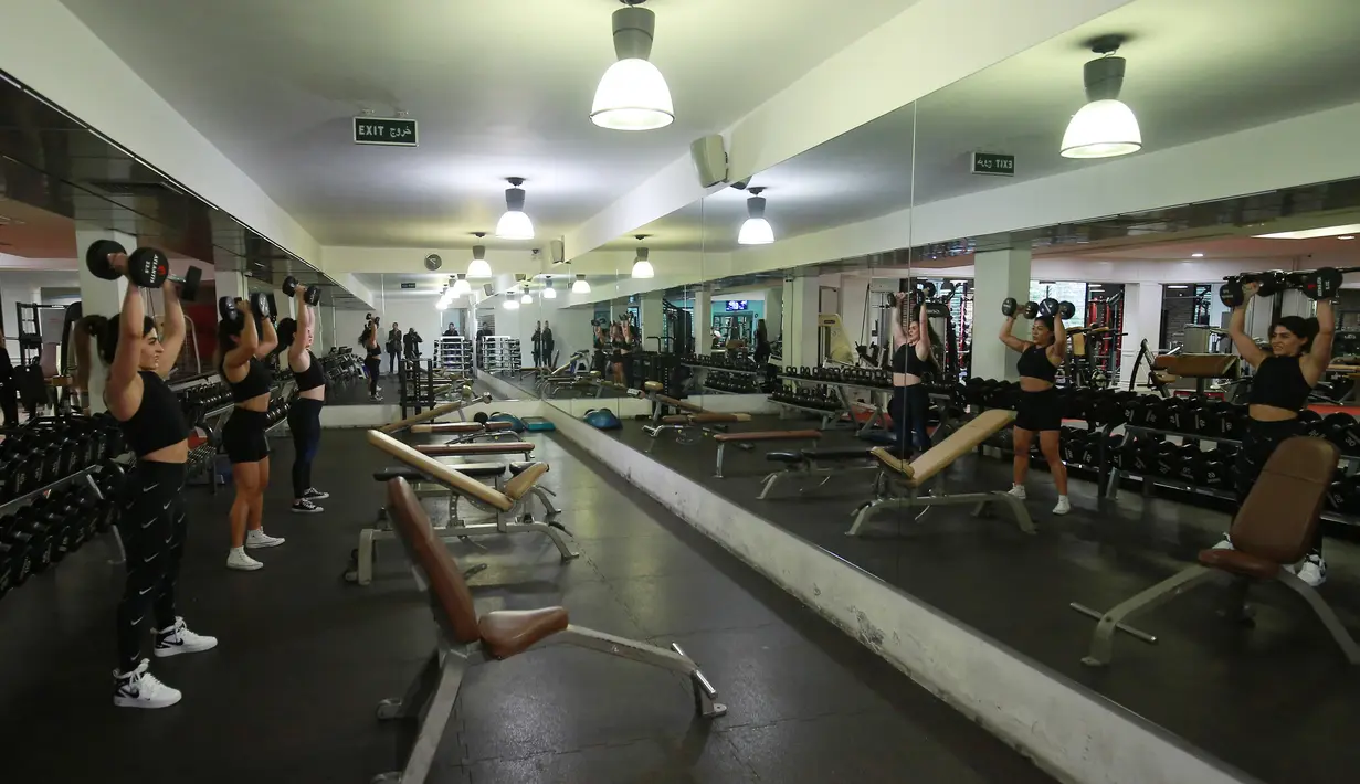 Binaragawan Yordania, Dana Sombouloglu berlatih dengan temannya di gym kota Amman 29 Januari 2020. Sombouloglu berupaya mematahkan anggapan masyarakat umum Yordania bahwa perempuan tidak boleh melakukan olah raga binaraga karena alasan budaya dan agama di negaranya. (AFP/Khalil Mazraawi)