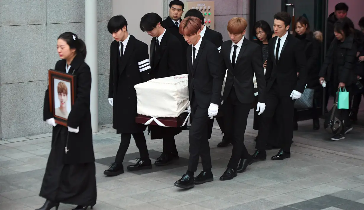 Kakak Jonghyun berjalan di depan pada pelepasan jenazah member boyband SHINee tersebut menuju tempat pemakaman dari Asan Hospital, Seoul, Kamis (21/12). Para member SHINee dan Super Junior mengangkat peti Jonghyun menuju mobil jenazah. (JUNG Yeon-Je/AFP)