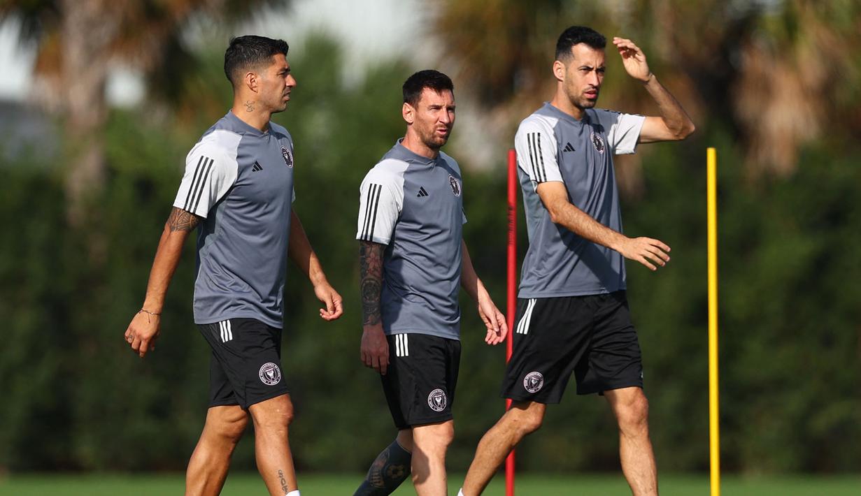Pemain baru Inter Miami, Luis Suarez (kiri) berjalan bersama Lionel Messi (tengah) dan Sergio Busquets saat latihan pramusim Inter Miami di Florida Blue Training Center, dekat DRV PNK Stadium, Florida, Fort Lauderdale, Sabtu (13/01/2024) waktu setempat. (AFP/Getty Images/Megan Briggs)