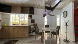 Seseorang berpose untuk foto di dalam rumah terbalik, di Guatavita, dekat Bogota, pada 29 Januari 2022. Usai peresmiannya, rumah terbalik telah menarik ratusan turis dalam waktu kurang dari sebulan. (Juan BARRETO / AFP)