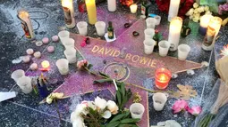 Lilin dan bunga diletakkan di atas nama penyanyi legendaris David Bowie di Hollywood Walk of Fame di Los Angeles, Senin (11/1). Bowie meninggal di usianya yang ke 69 tahun dan baru saja merilis album ke-25 nya yaitu "Blackstar". (REUTERS/ Aron Ranen)