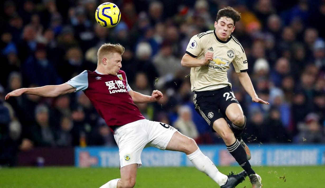 Gelandang Manchester United, Daniel James, berebut bola dengan pemain Burnley, Ben Mee, pada laga Premier League di Stadion Turf Moor, Sabtu (28/12). Burnley takluk 0-2 dari Manchester United. (AP/Martin Rickett)