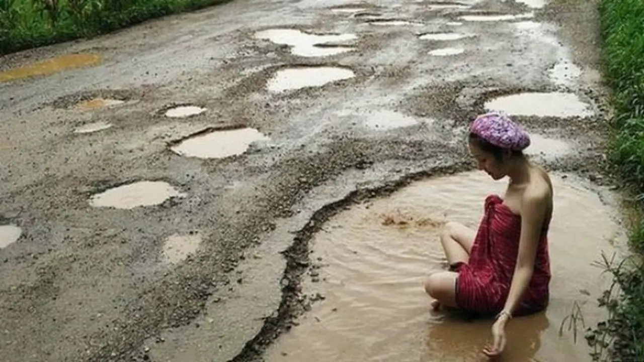 Palm 'mandi' di kubangan air di jalanan yang rusak sebagai bentuk protes terhadap pemerintah