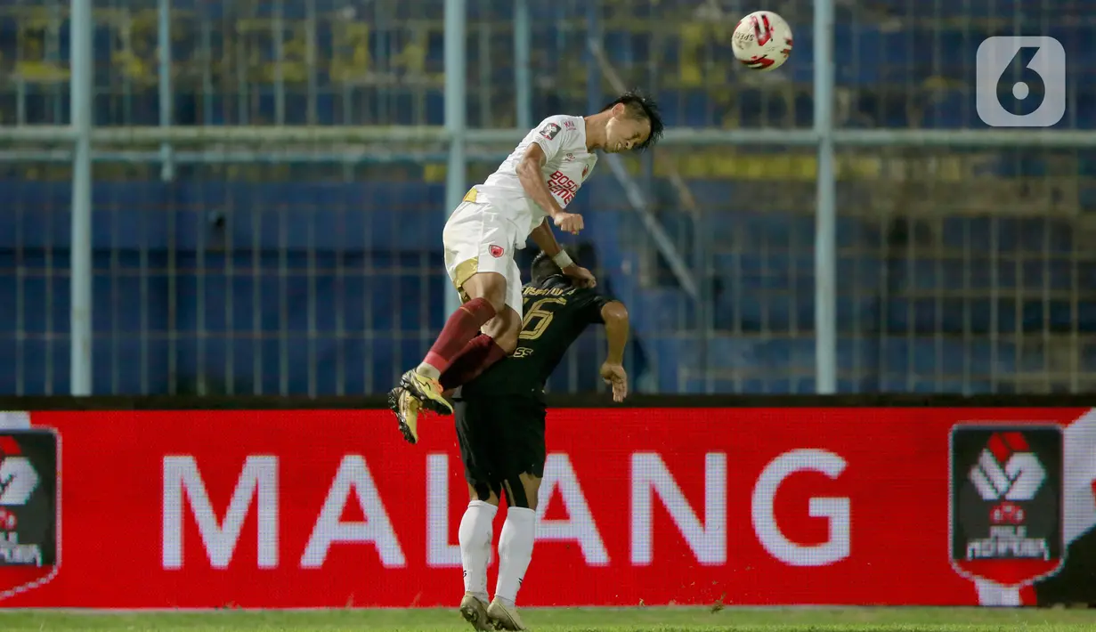 Pemain PSM Makassar, Abdul Rahman (kiri) menyundul bola melewati pemain PSIS Semarang, Fredyan Wahyu Sugiyantoro dalam laga Perempat final Piala Menpora 2021 di Stadion Kanjuruhan, Malang, Jumat (9/4/2021). PSIS vs PSM berakhir dengan skor 2-4 via adu tendangan penalti. (Bola.com/Arief Bagus)